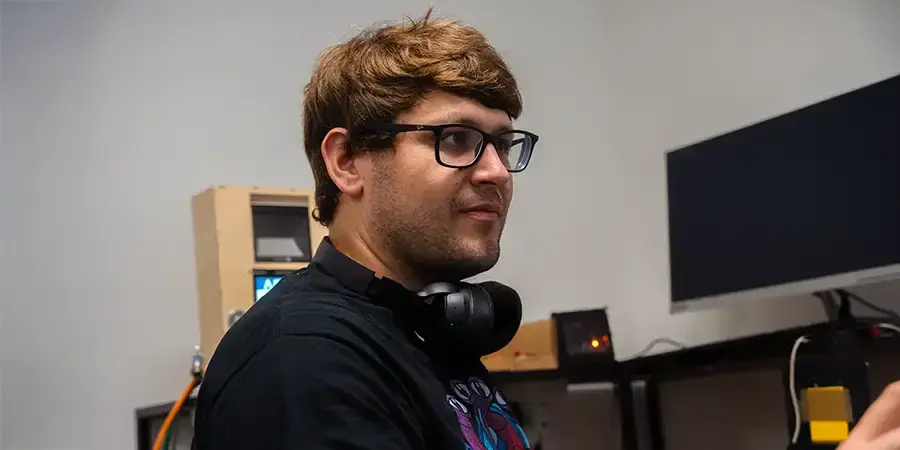 Arivo Mitarbeiter steht in einem Raum mit technischen Geräten und bedient diese.