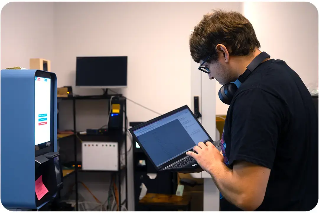 Arivo Mitarbeiter mit Laptop vor Arivo Entry-/Exit-Station.